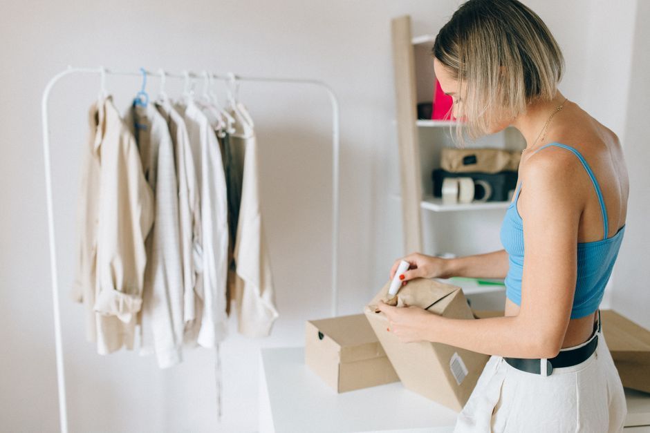 Small business owner calmly packing parcels while Amazon handles customer service