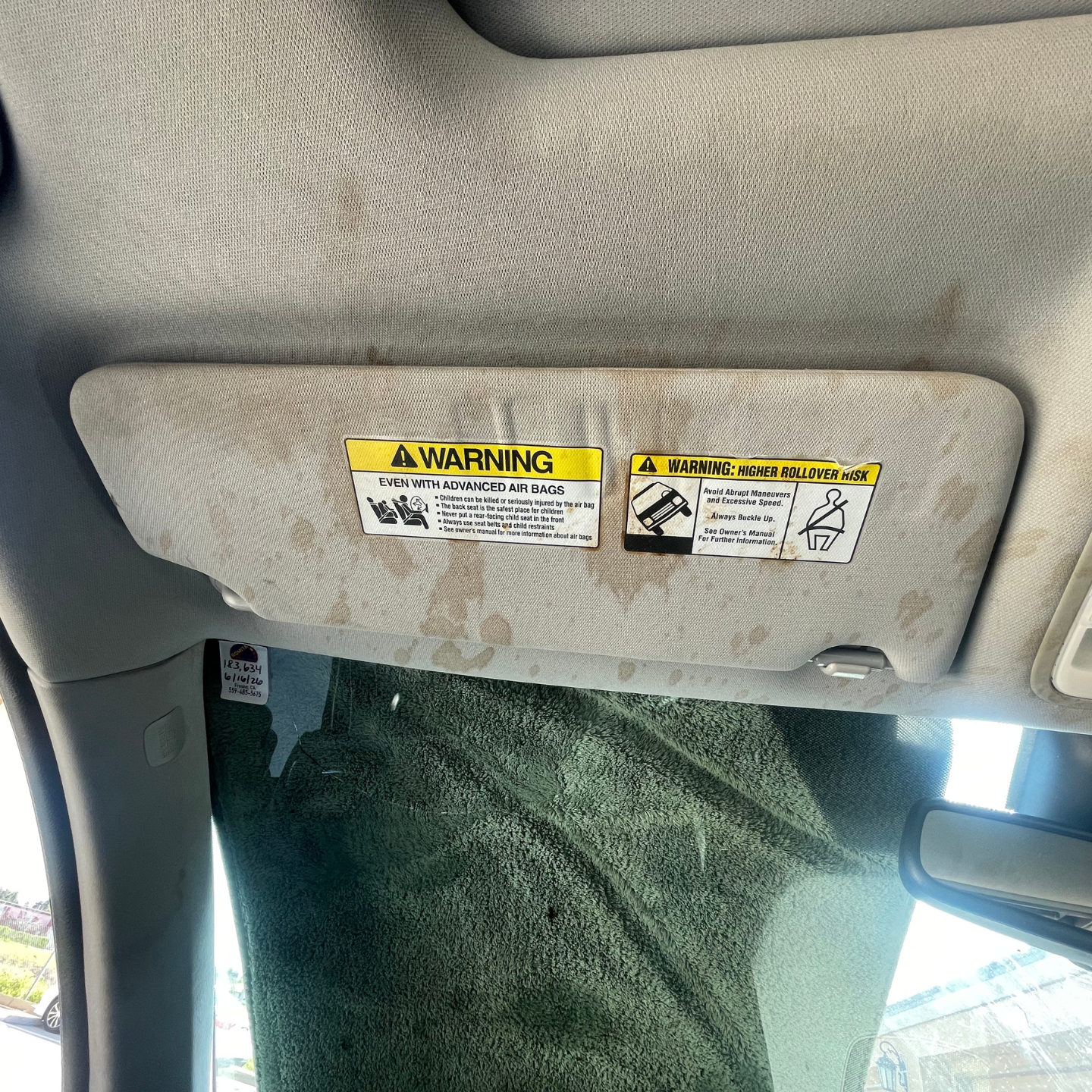 The inside of a car with a steering wheel and seats before cleaning