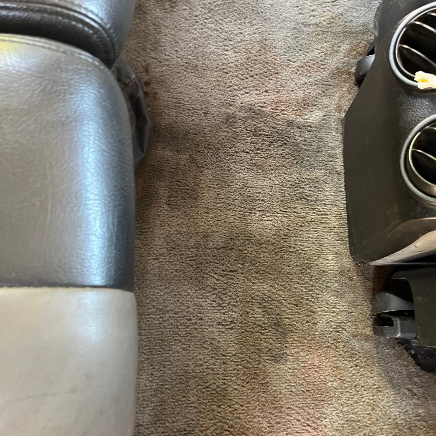 A close up of a carpeted floor next to a chair