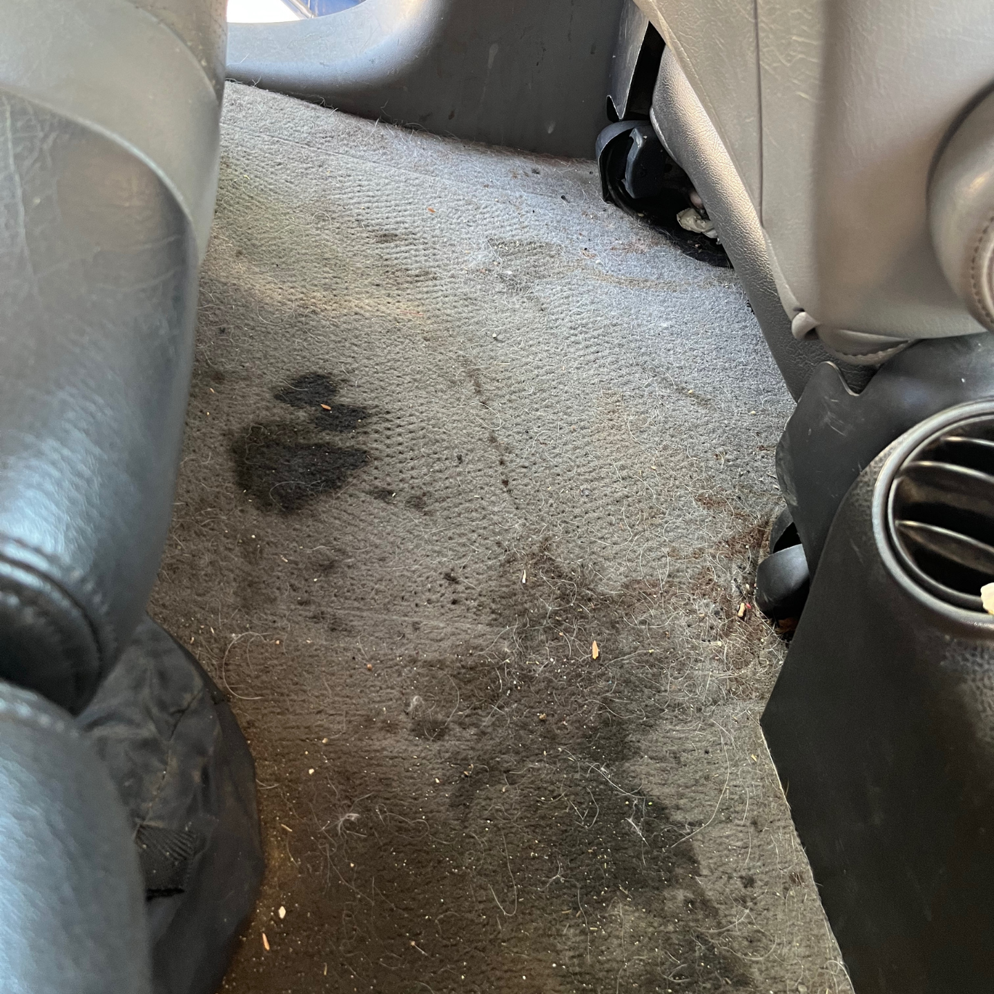 A car with a dirty carpet and a dirty air vent