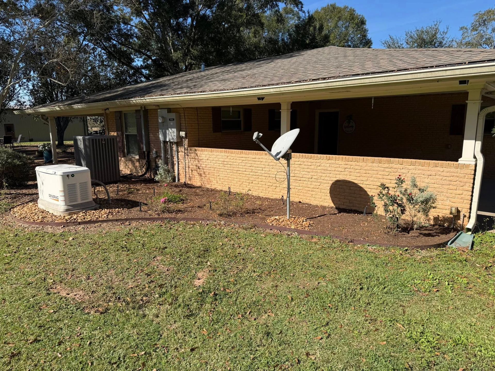 Single-story brick house with a satellite dish, HVAC unit, and a grassy front yard.