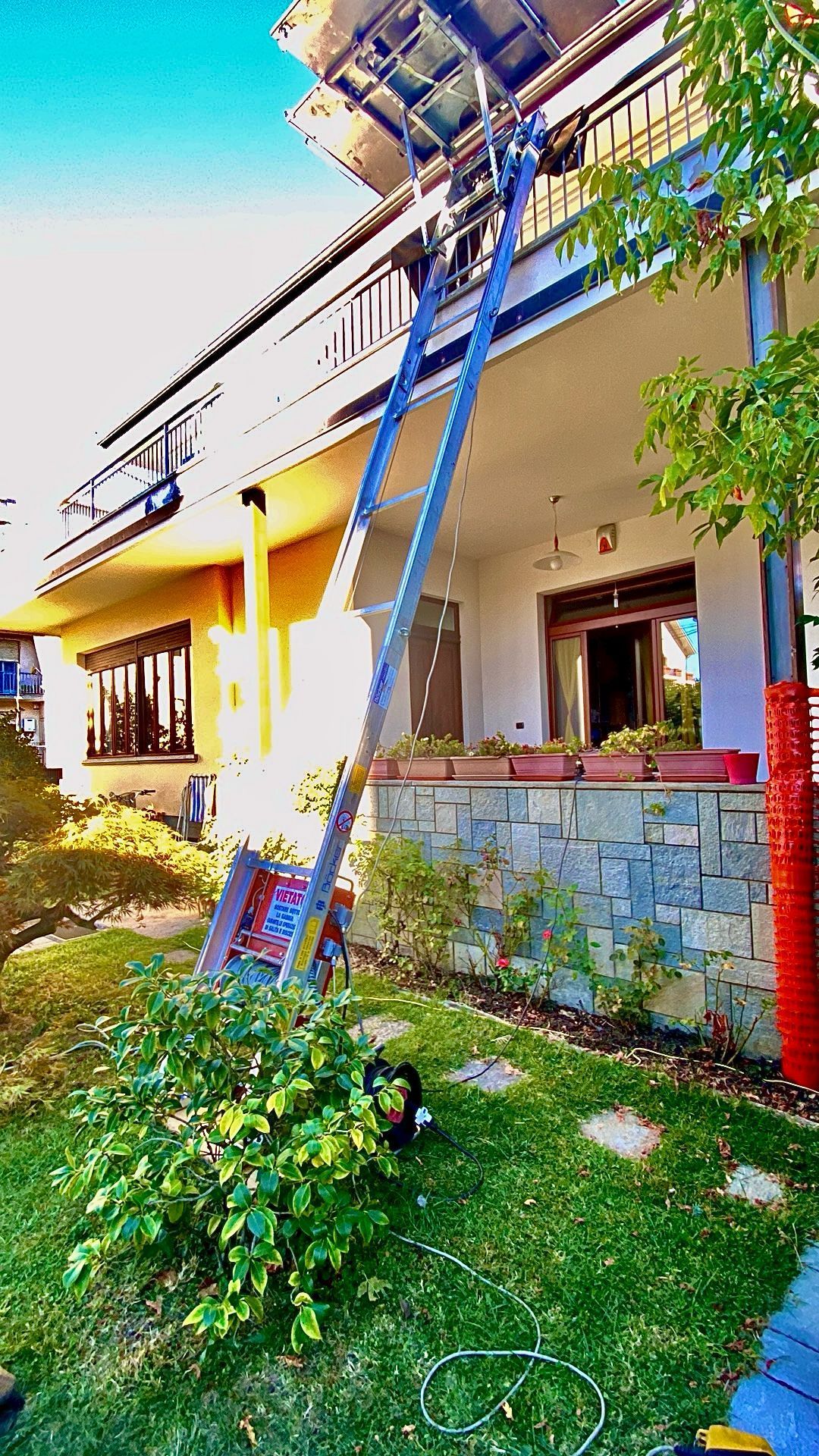 Un ascensore mobile si estende fino al balcone di una casa, scaricando i mobili.