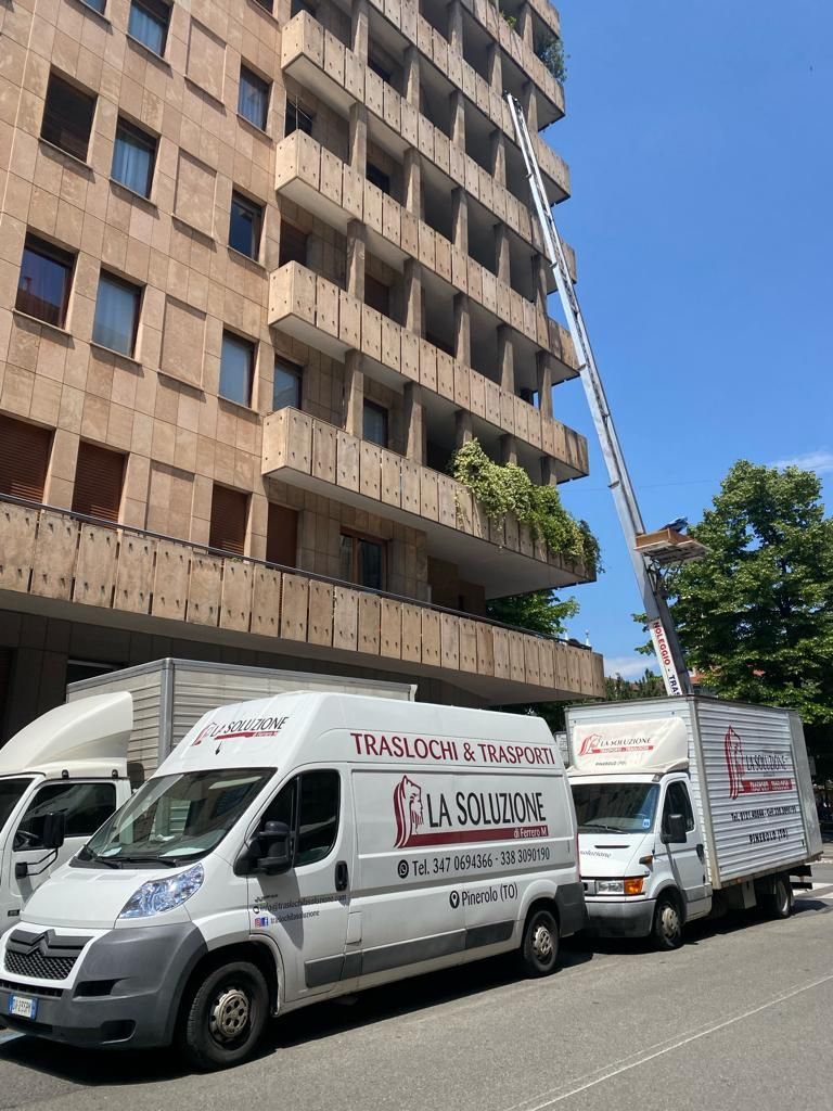 Camion per traslochi e un ascensore appoggiati a un grattacielo, probabilmente per un trasloco.