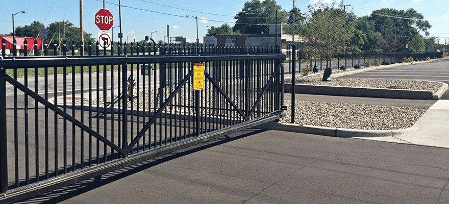 A Sliding Gate Is Open To A Parking Lot With A Stop Sign In The Background – Mishawaka IN - Milestone Fence