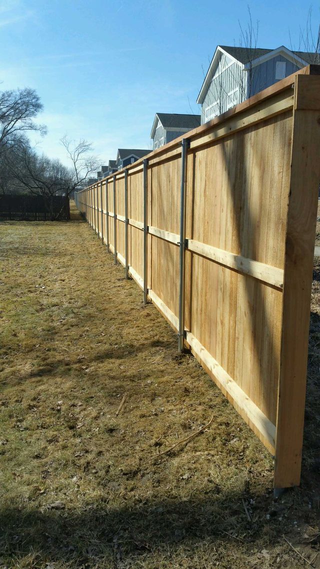 A Wooden Fence Is Sitting In The Middle Of A Grassy Field – Mishawaka IN - Milestone Fence