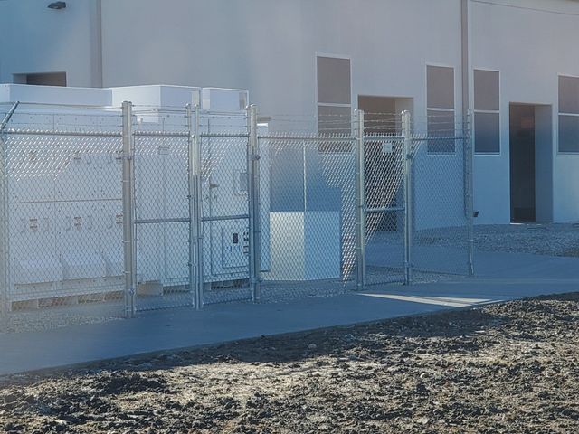 A Chain Link Fence Surrounds A White Building – Mishawaka IN - Milestone Fence