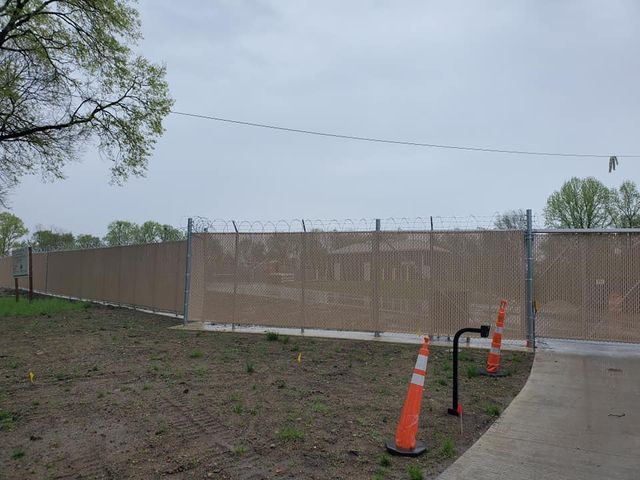 A Fence With Barbed Wire Is Surrounded By Orange Cones – Mishawaka IN - Milestone Fence