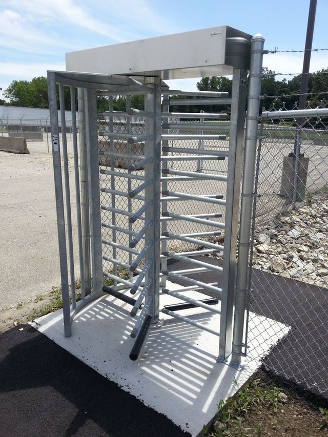 A Metal Turnstile Is Sitting On A Concrete Surface – Mishawaka IN - Milestone Fence