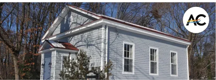 Light blue building with white trim, red roof, and bare trees in winter.