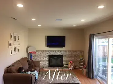 A living room with a couch , fireplace , television and sliding glass door.