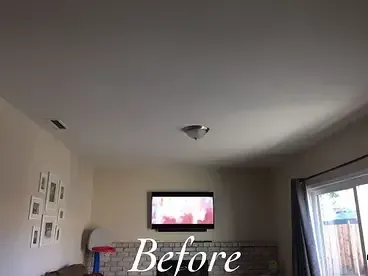 A living room with a flat screen tv mounted to the ceiling.