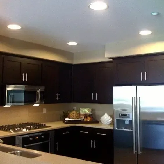 A kitchen with stainless steel appliances and dark cabinets