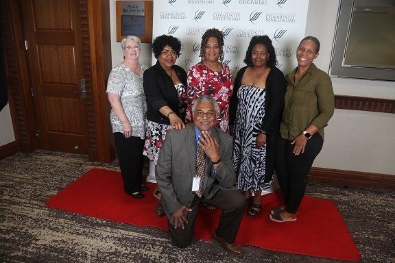 a group of people are posing for a picture on a red carpet .