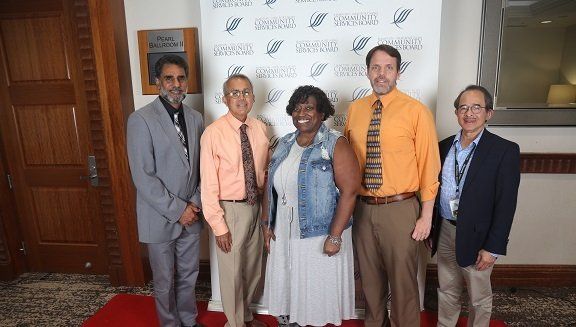 a group of people are posing for a picture on a red carpet .