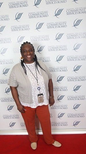 a woman is standing in front of a wall with logos on it .