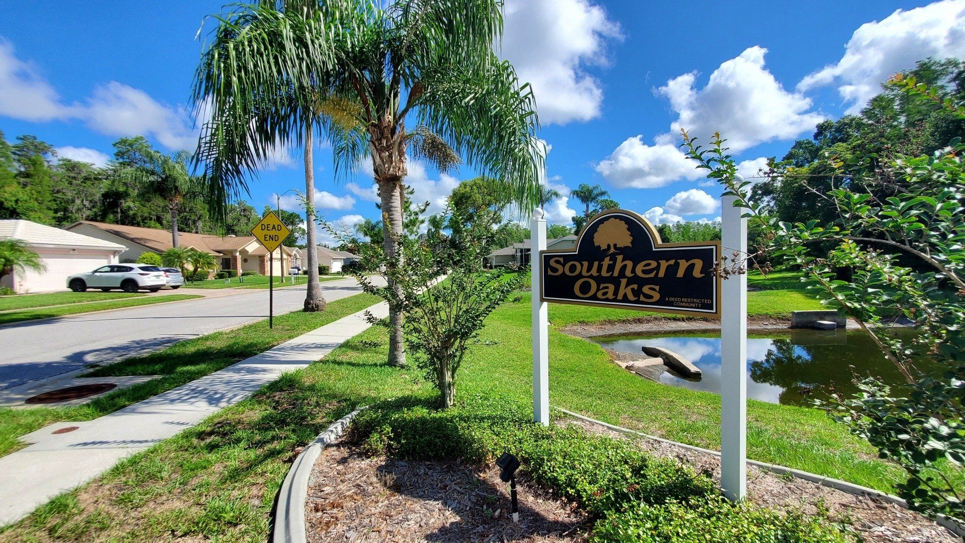 A sign for southern oaks is sitting on the side of the road.