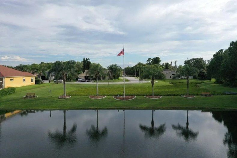 An aerial view of a pond with a flag pole in the middle