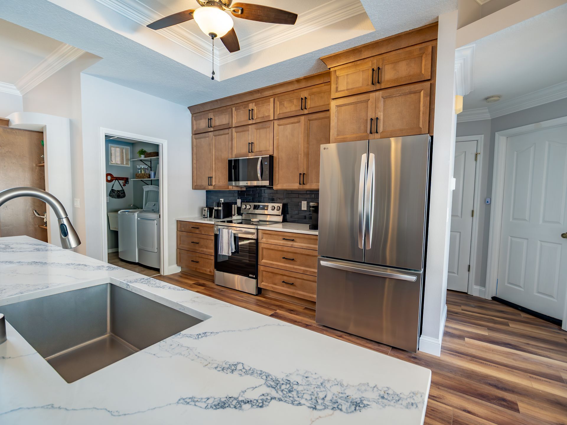 Kitchen with wood cabinets, stainless steel appliances, and a marble countertop.
