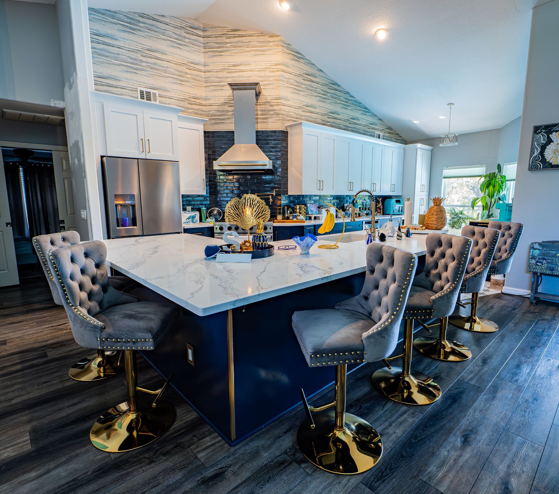 Modern kitchen with a large island, seating, and blue and white decor.