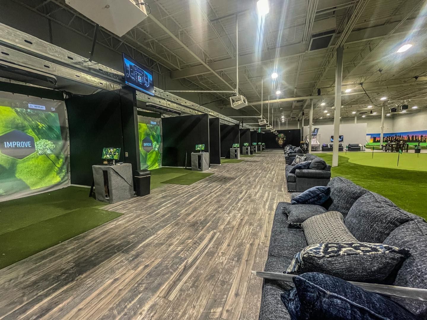 A large room with a lot of furniture and a golf course in the background.