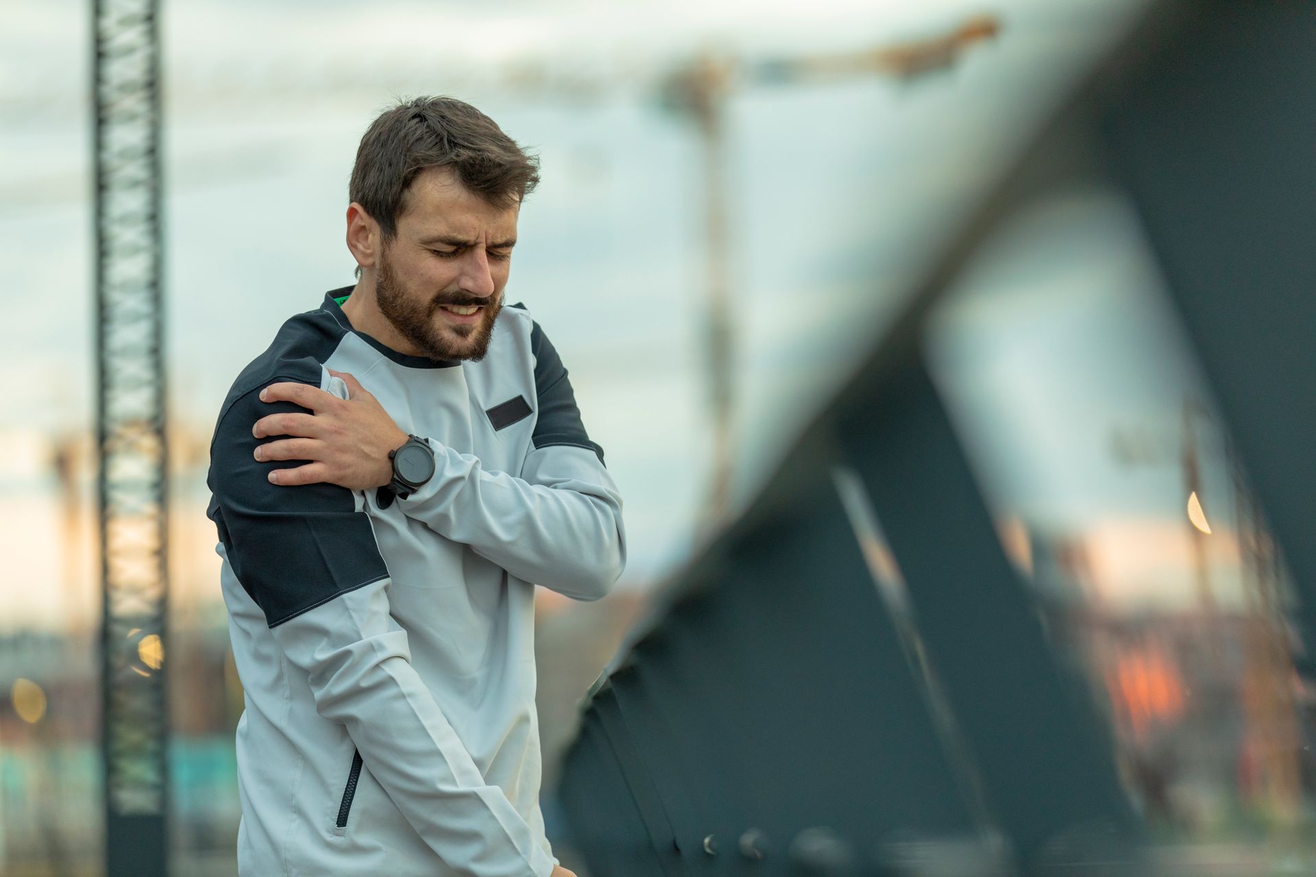 A man is holding his shoulder in pain.