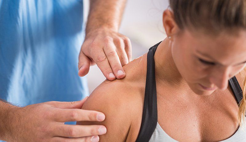 A woman is getting a massage from a doctor.