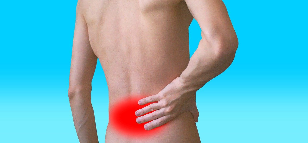 A man is holding his lower back in pain.
