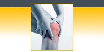 A person is holding their knee in pain. A person is holding their knee in pain.