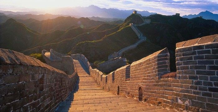 A grande muralha da china é uma muralha de tijolos muito longa cercada por montanhas.