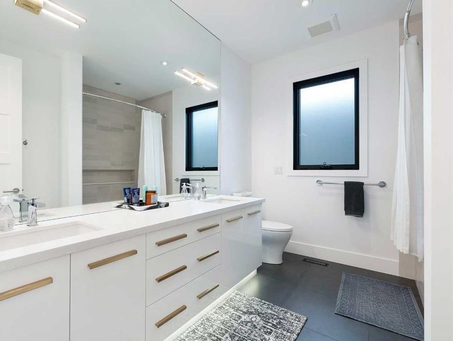 Eyeglasses and a pen rest on a home floor plan printed on paper, set against a wooden surface.