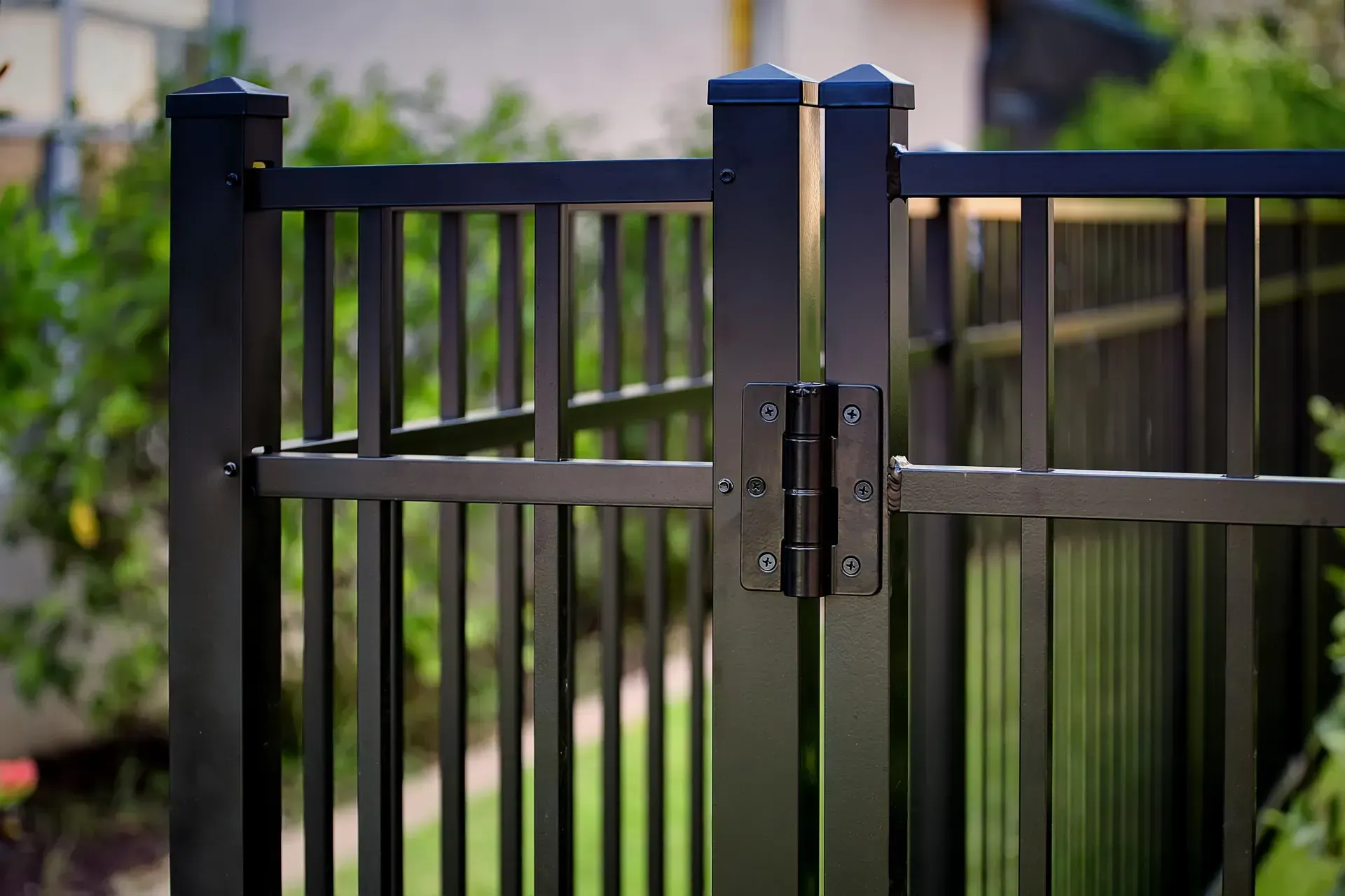 A close up of a black metal fence with a gate.