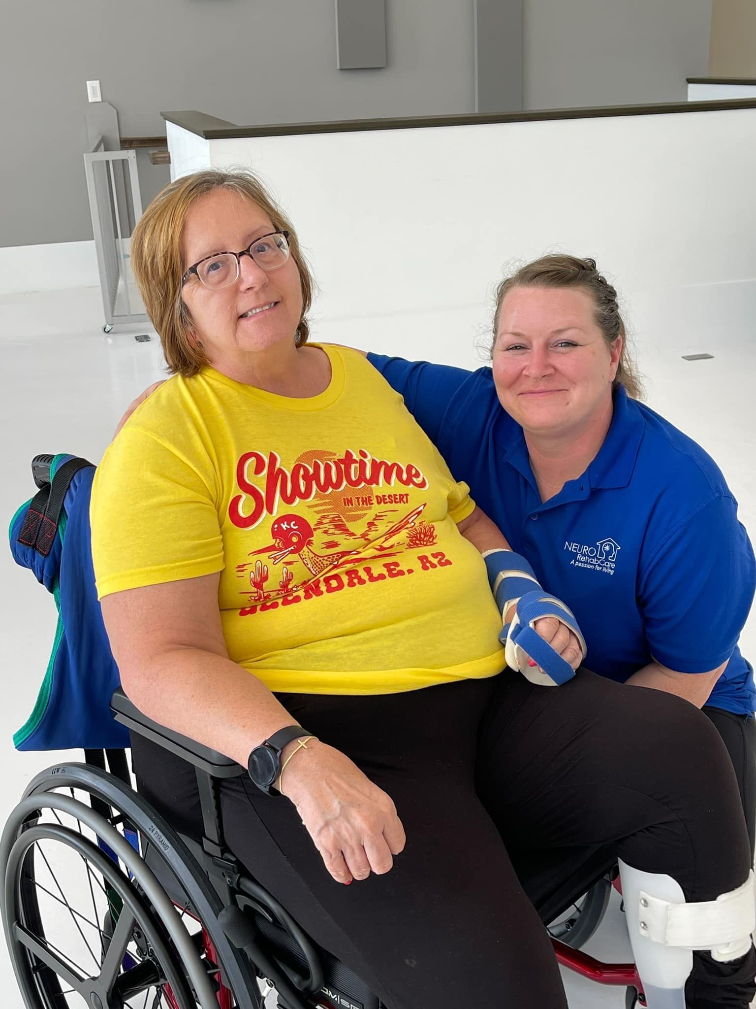 A woman in a wheelchair is posing for a picture with another woman.
