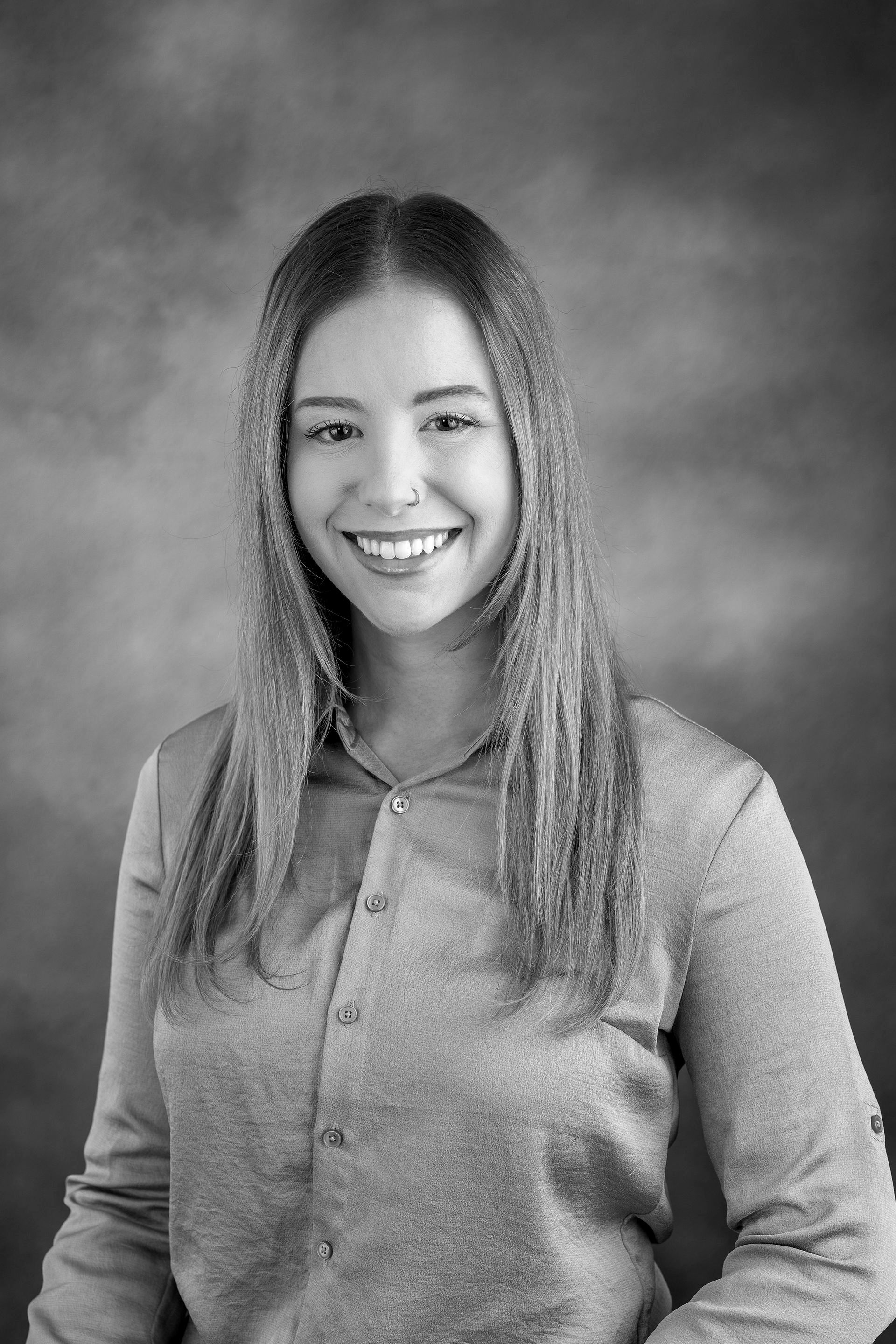 Alexandra Hoefer. A black and white photo of a smiling woman in a sweater.