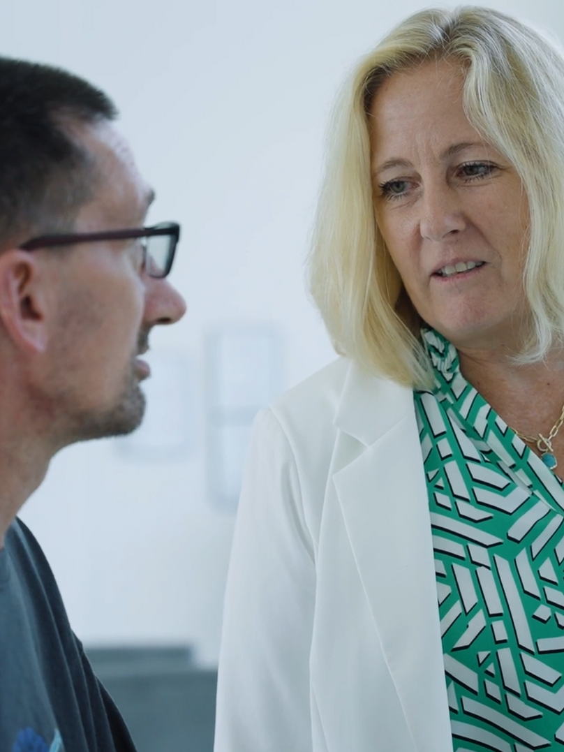 A man and a woman are talking to each other in a room.