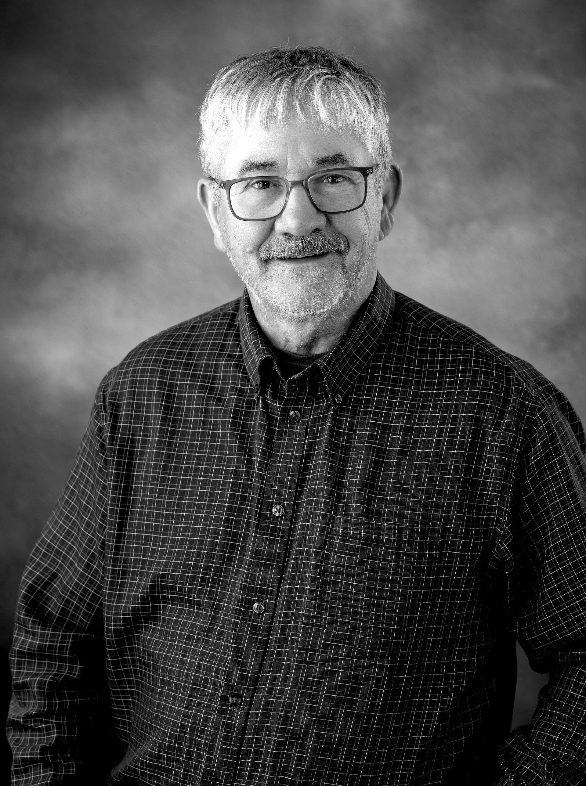 Jim Aberg. A black and white photo of a man with glasses and a beard.