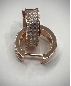 Un par de pendientes de aro de oro con diamantes sobre una superficie blanca.