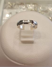 Un anillo de plata reposa sobre un cojín blanco.