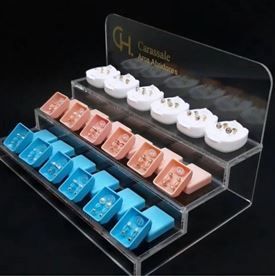 Una vitrina de acrílico transparente llena de aretes de diferentes colores.