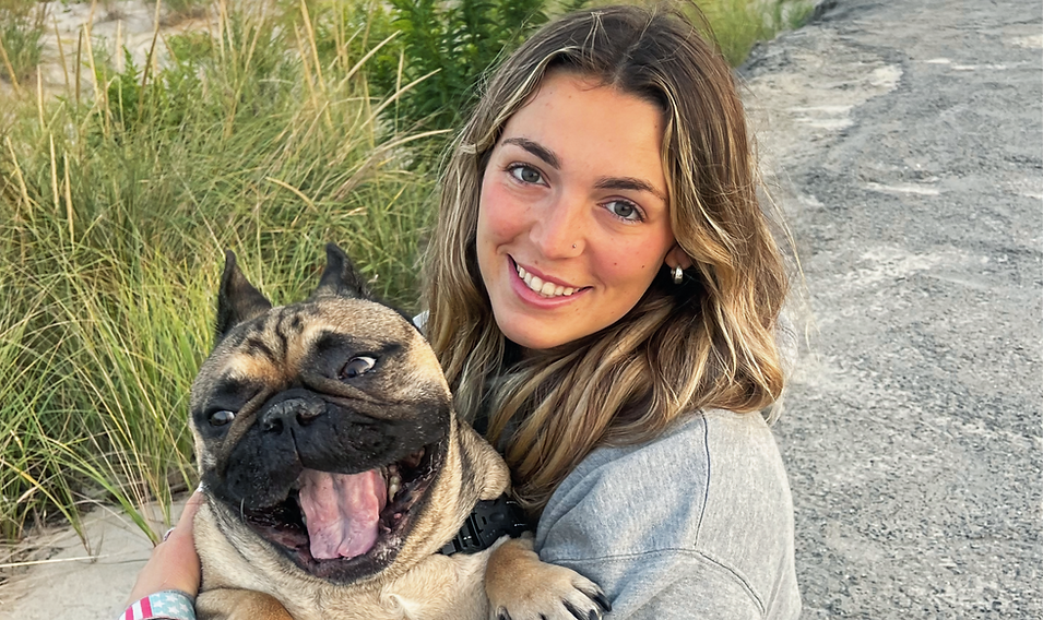 A woman is holding a pug dog in her arms.