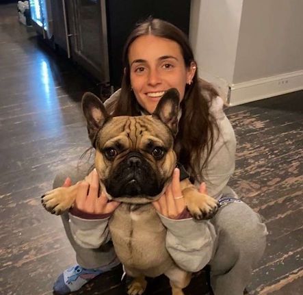 Mia Agresti holding French Bulldog in her arms.
