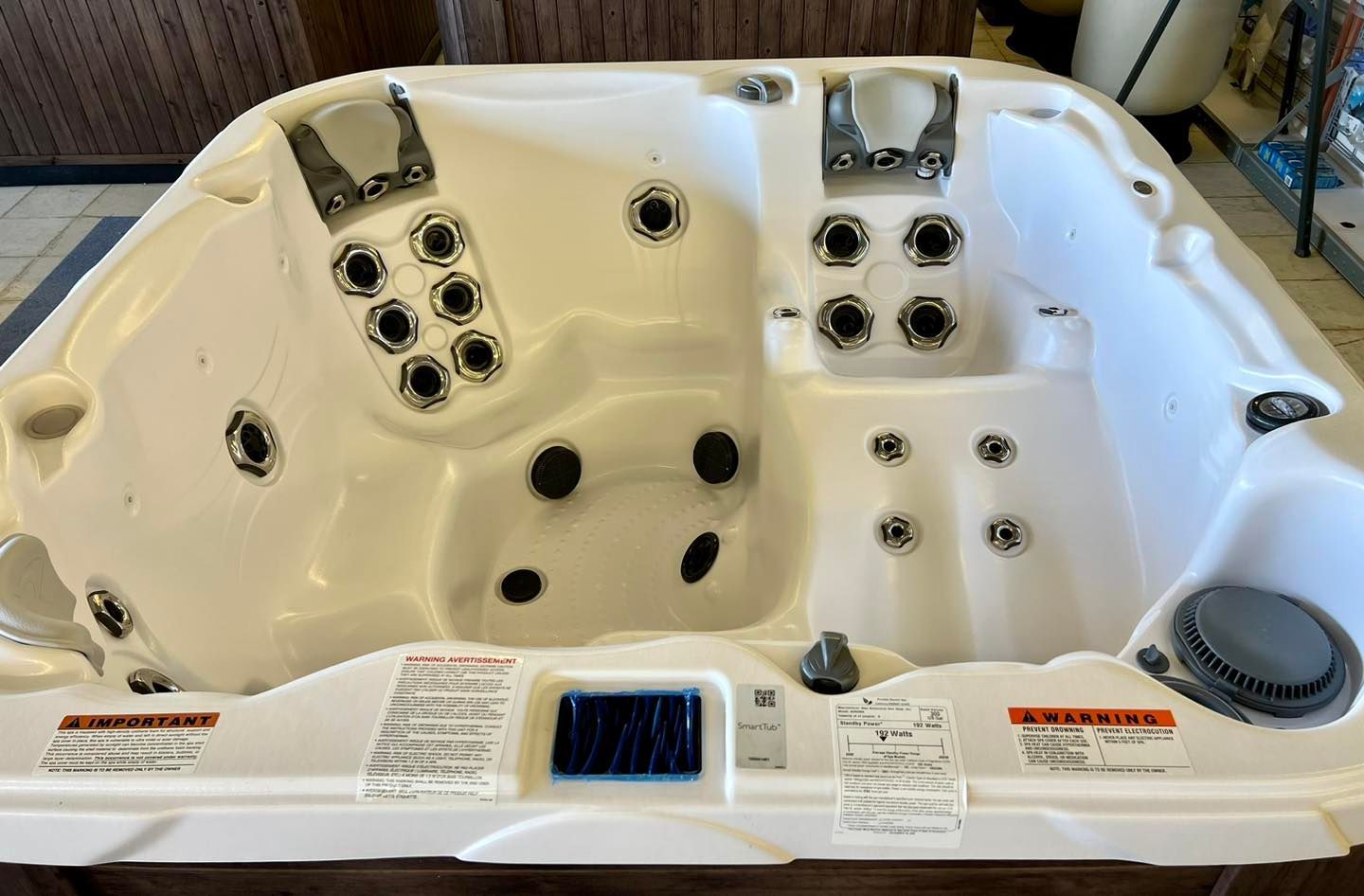 A white hot tub is sitting on top of a wooden table.