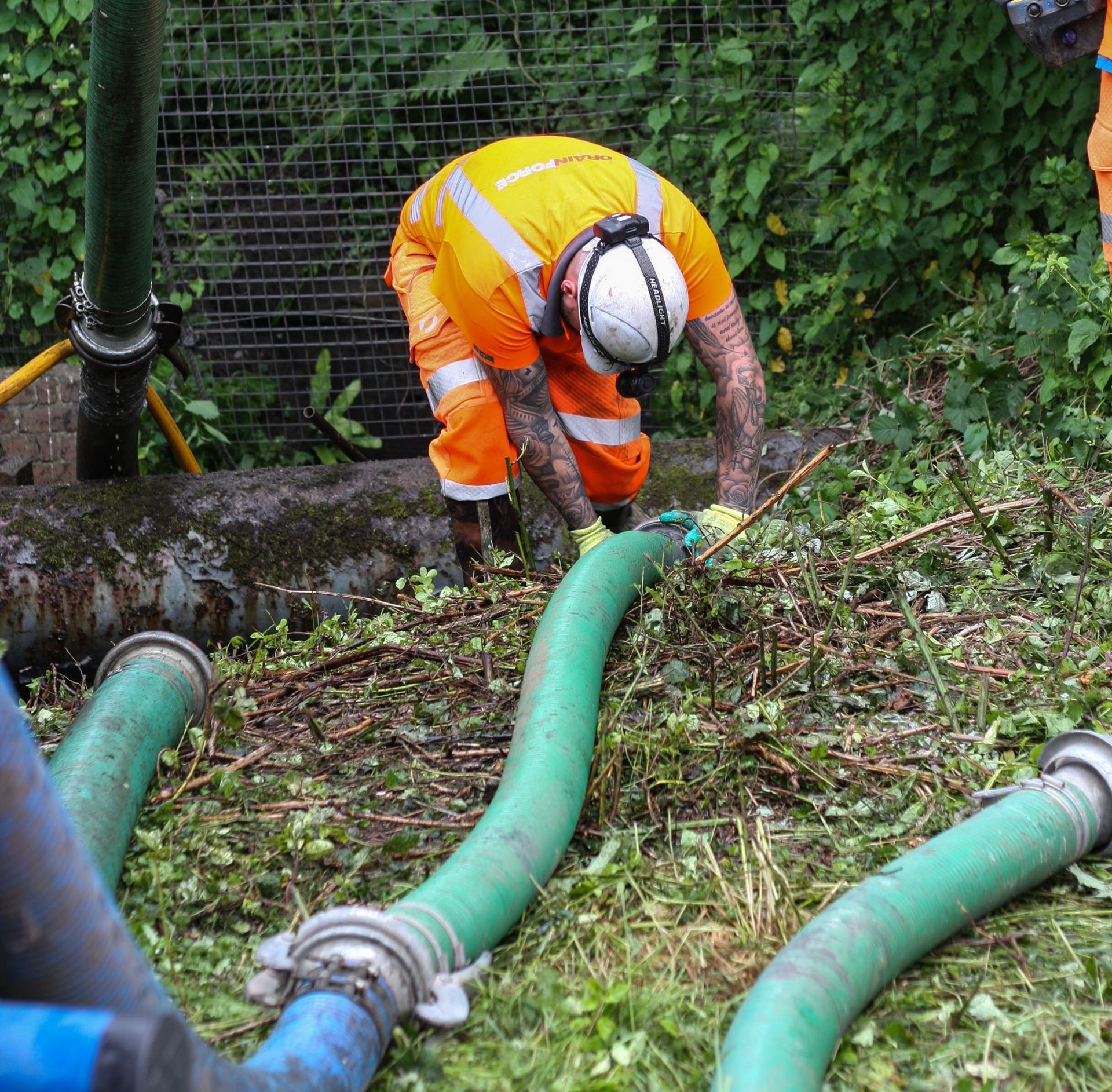 Drainforce employee setting out suction tube from cesspit to tanker
