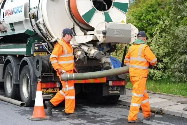Drainforce staff unloading suction tube from 4,000 gallon cesspit tanker.