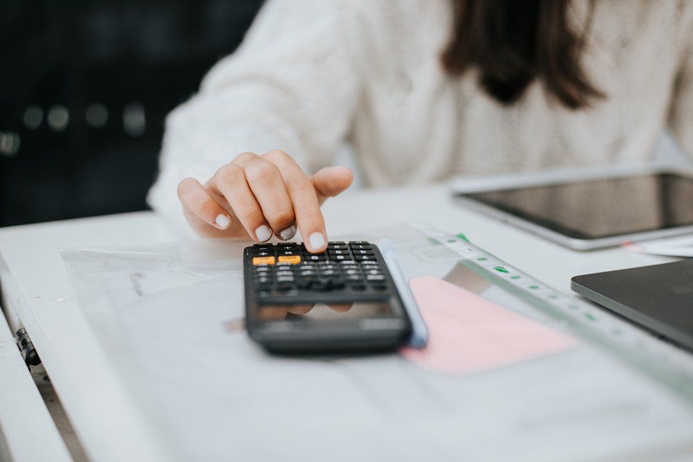 Woman Computing Budget With Calculator — Scottsdale, AZ — J.B. Martin Insurance Agencies Woman Computing Budget With Calculator — Scottsdale, AZ — J.B. Martin Insurance Agencies