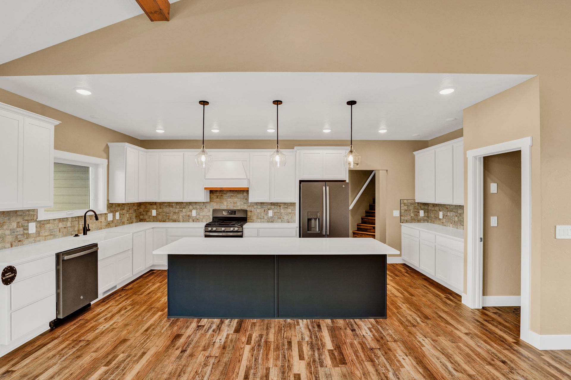 Bright open kitchen with white cabinets and dark island in Great Falls MT home