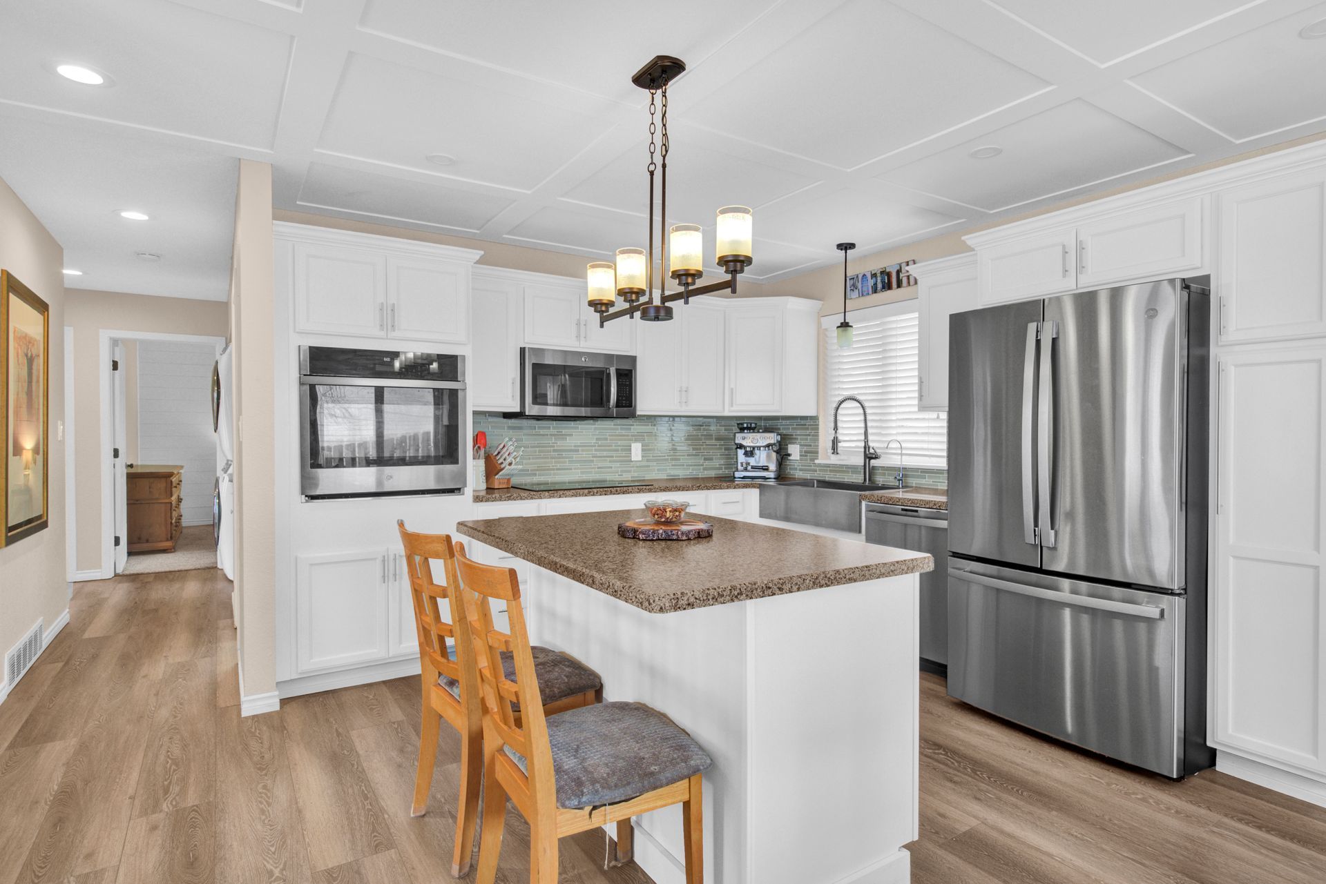 Modern white kitchen with stainless steel appliances and island in Great Falls MT home
