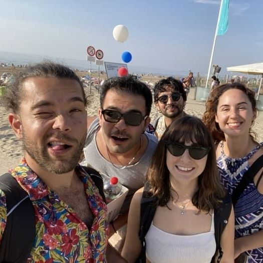 A group of people are posing for a picture on the beach