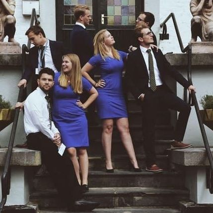 A group of people are posing for a picture on the steps of a building