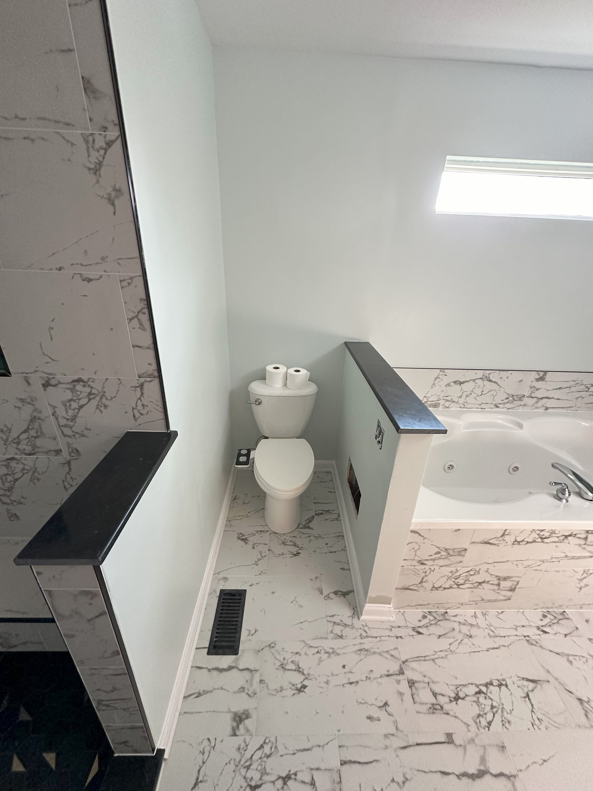 a bathroom with a toilet , tub and shower .