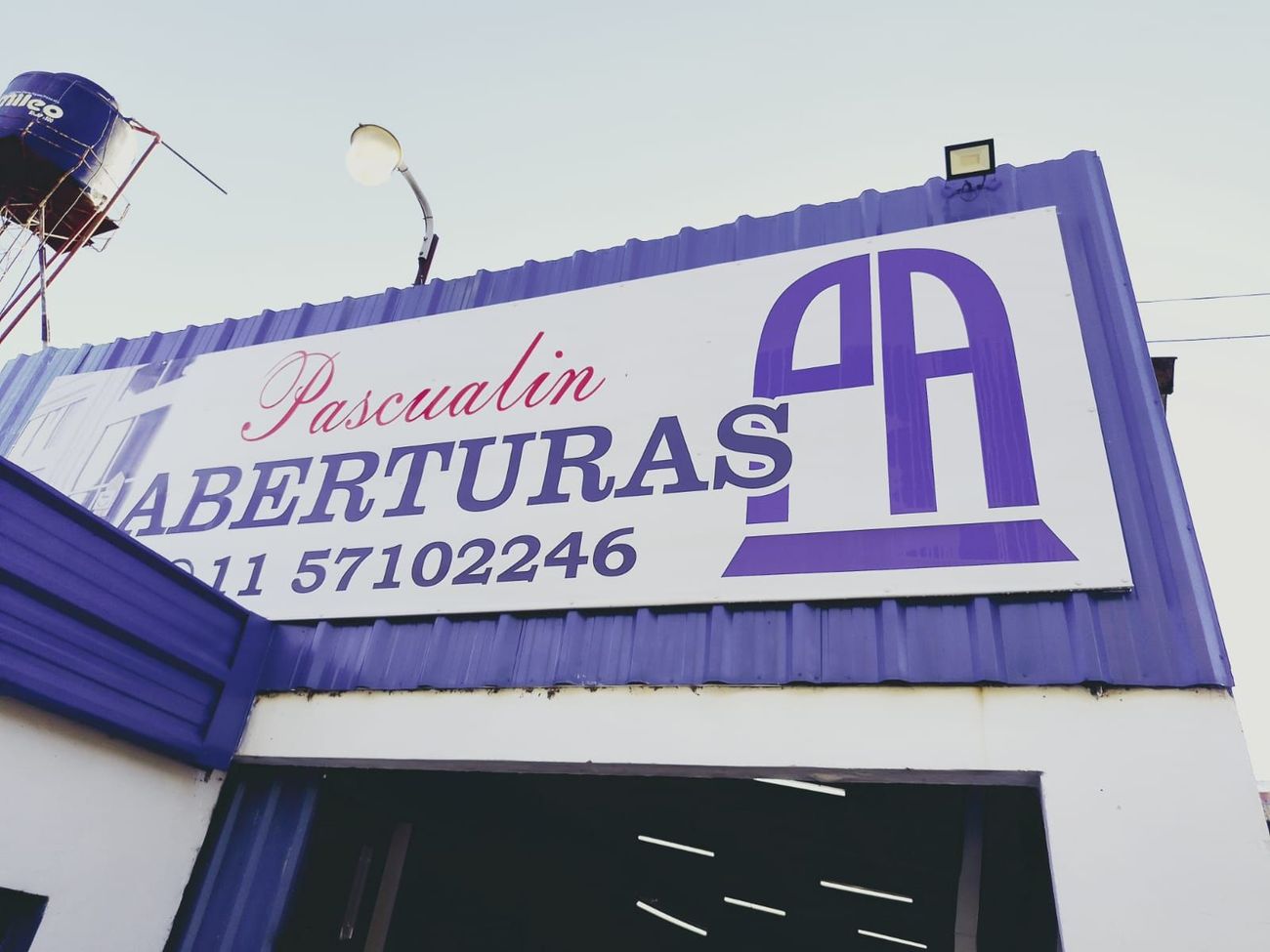 Un letrero morado y blanco en la fachada de la tienda dice